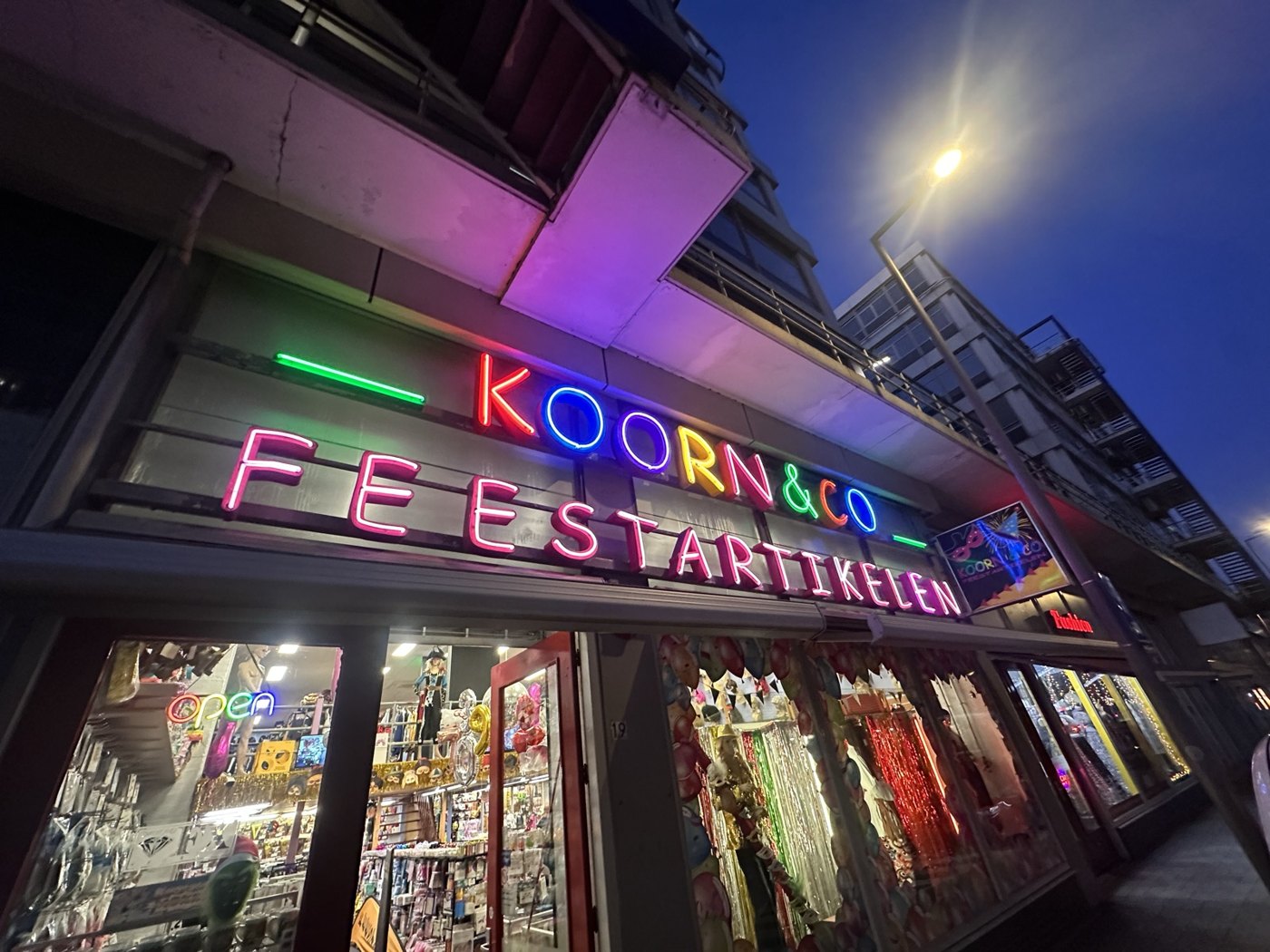 De verlichte gevel van Koorn & Co aan de Motorstraat 19 in de avond