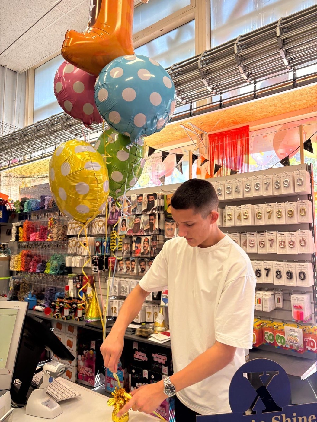 Stef Koorn maakt een tros ballonnen klaar in de winkel